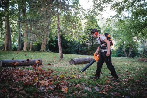 Un jeune en formation en train de souffler les feuilles