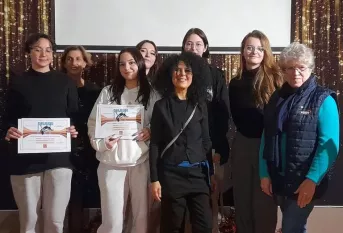 Groupe de personnes enseignant et élèves qui posent avec le diplôme.