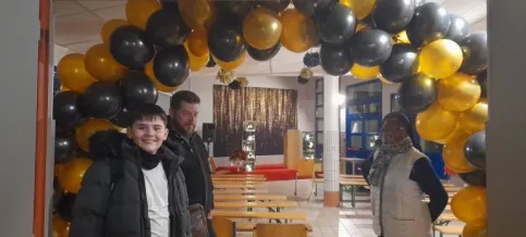 Vue de la salle du foyer décoré avec un jeune qui pose.